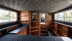 Un intérieur compact comprenant un lit, des étagères intégrées et un coin salon.