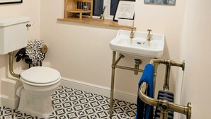 Une salle de bain avec des toilettes, un lavabo et une fenêtre.