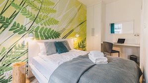 Una habitación de hotel con una cama, un escritorio y una silla.
