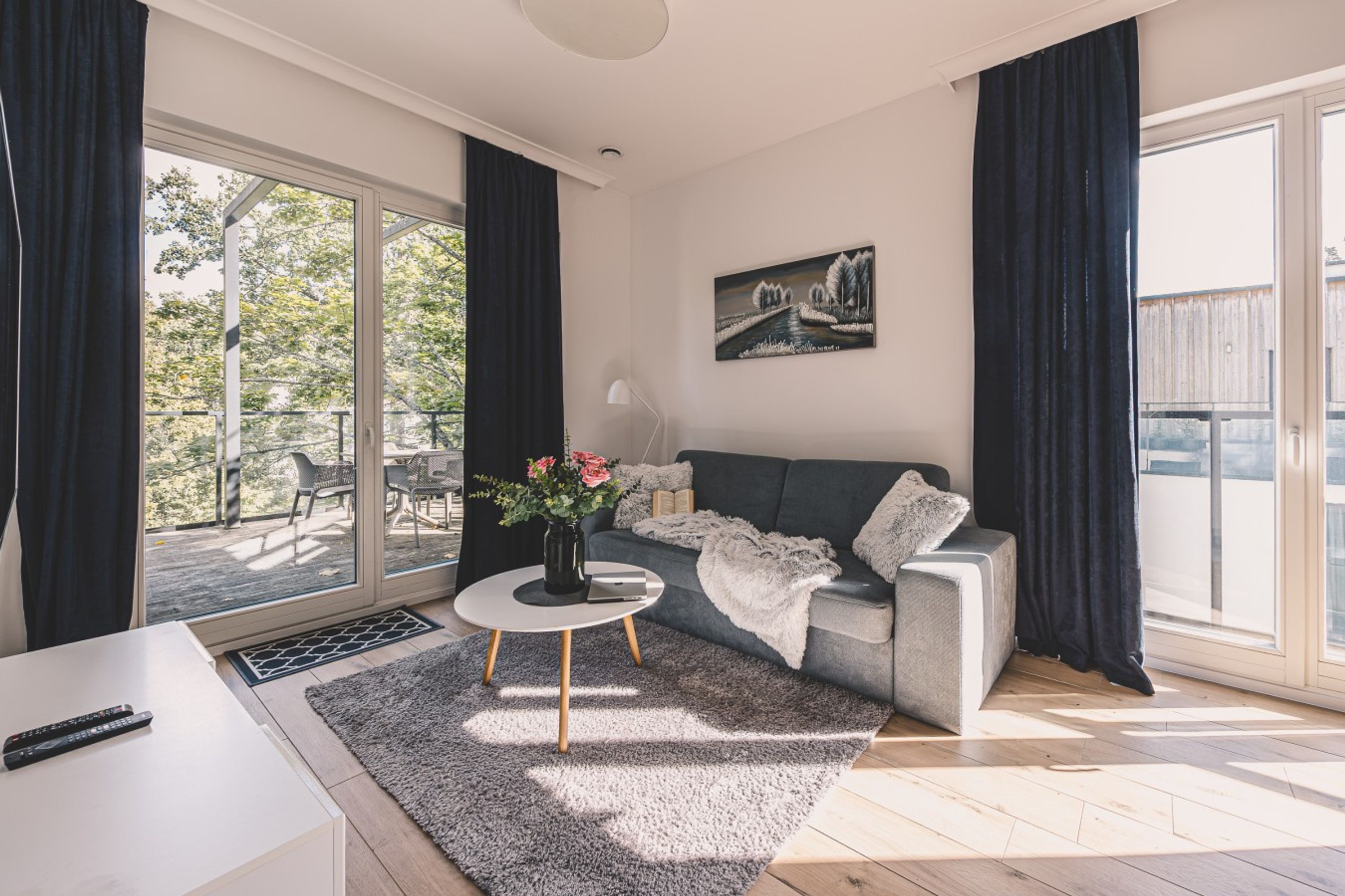 Una sala de estar moderna con un sofá, una mesa de centro y un cuadro en la pared.