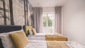 A hotel room with two beds, a large window with curtains, and a view of trees outside. - Bisonte Apartament 2 Sypialnie Du y Taras (Hajnowka)