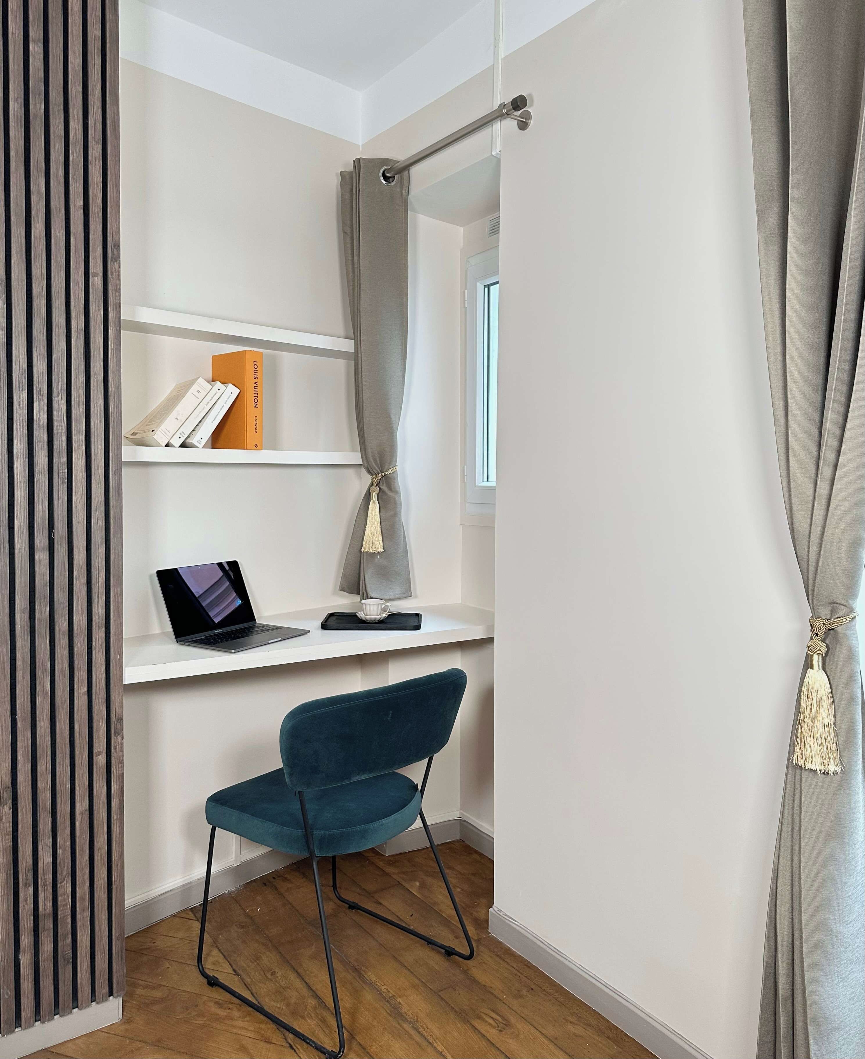 A modern room with a desk, chair, shelves, and a window.