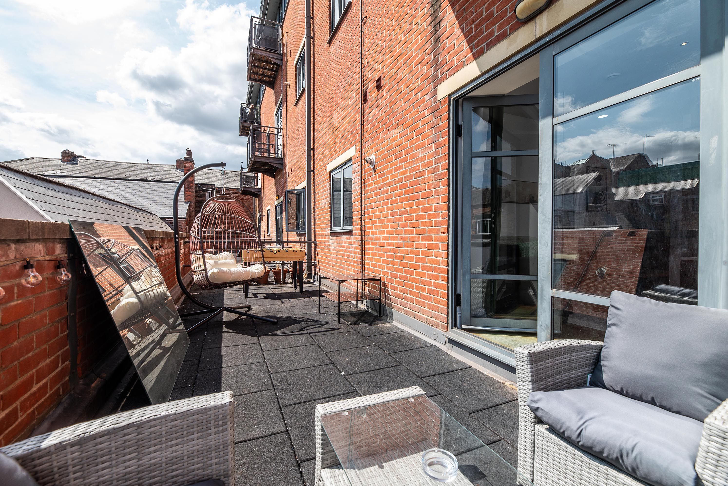A courtyard with a patio area, outdoor furniture, and a glass door leading to a covered space.