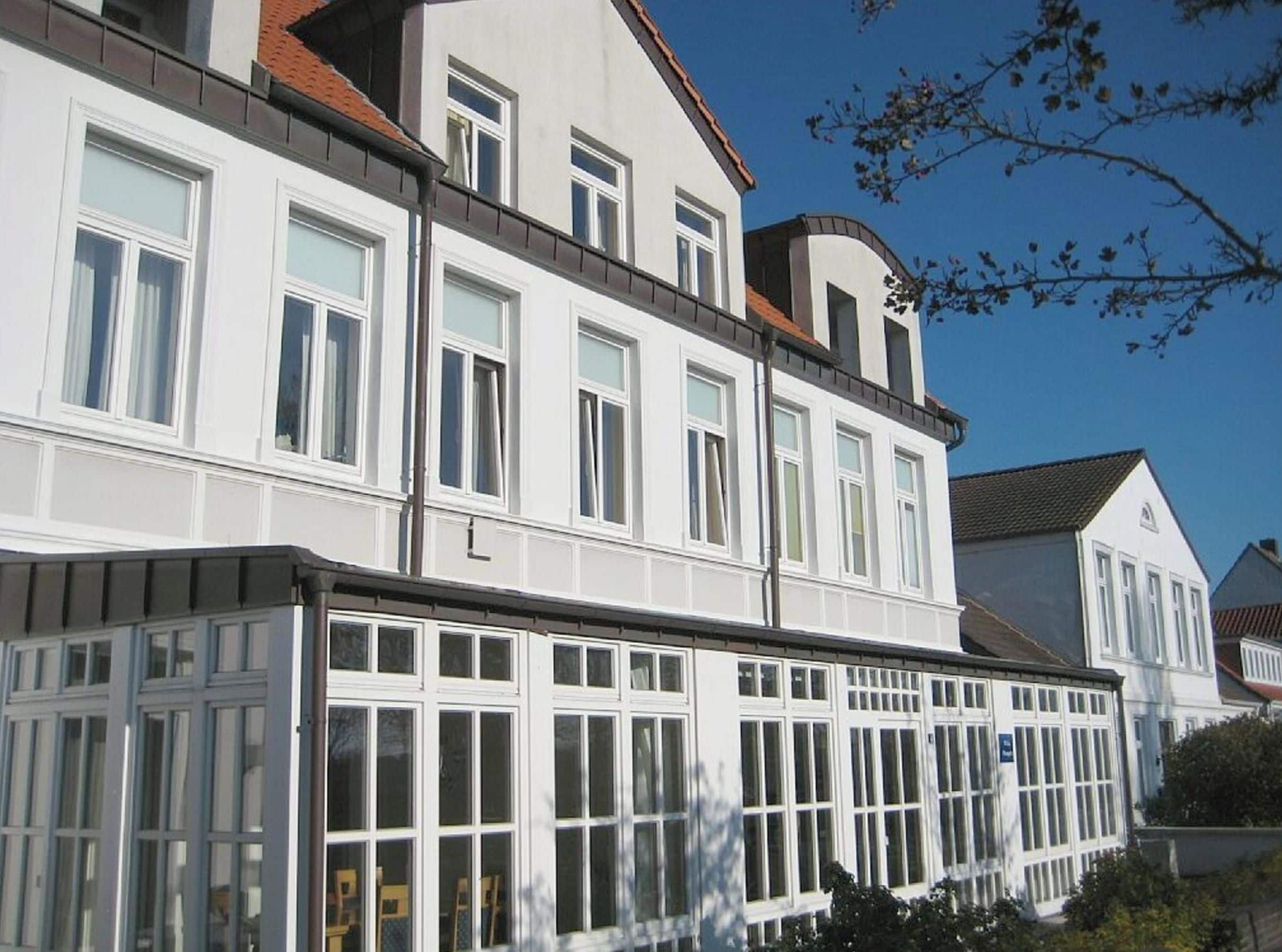 A multi-story building with white exterior walls and multiple windows.