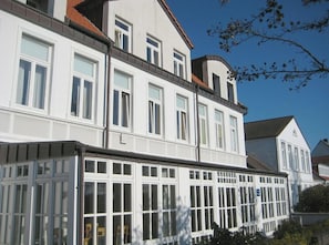 A multi-story building with white exterior walls and multiple windows. - Villa Seegatt 08 (Norderney)