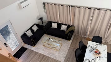 A modern living room with a sectional sofa, a coffee table, and a dining area with a table and chairs.