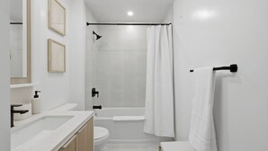 Un baño moderno con ducha, inodoro y lavabo.