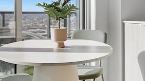 Un comedor moderno con una mesa redonda, dos sillas y una planta en maceta.