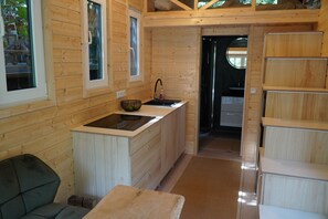 Ein gemütliches Holzhaus-Interieur mit einer Küchenzeile, einem Essbereich und einer kleinen Sitzecke.