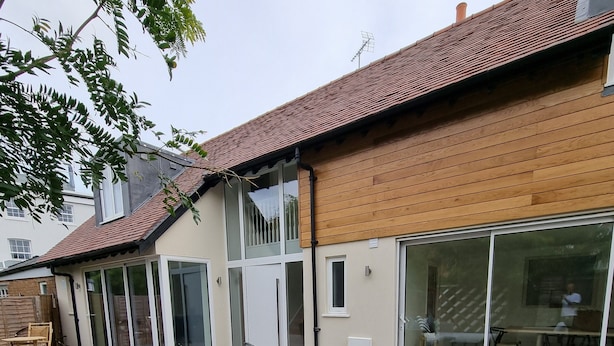 Uma casa com área de varanda, mobiliário de exterior e porta de correr que dá para o interior.