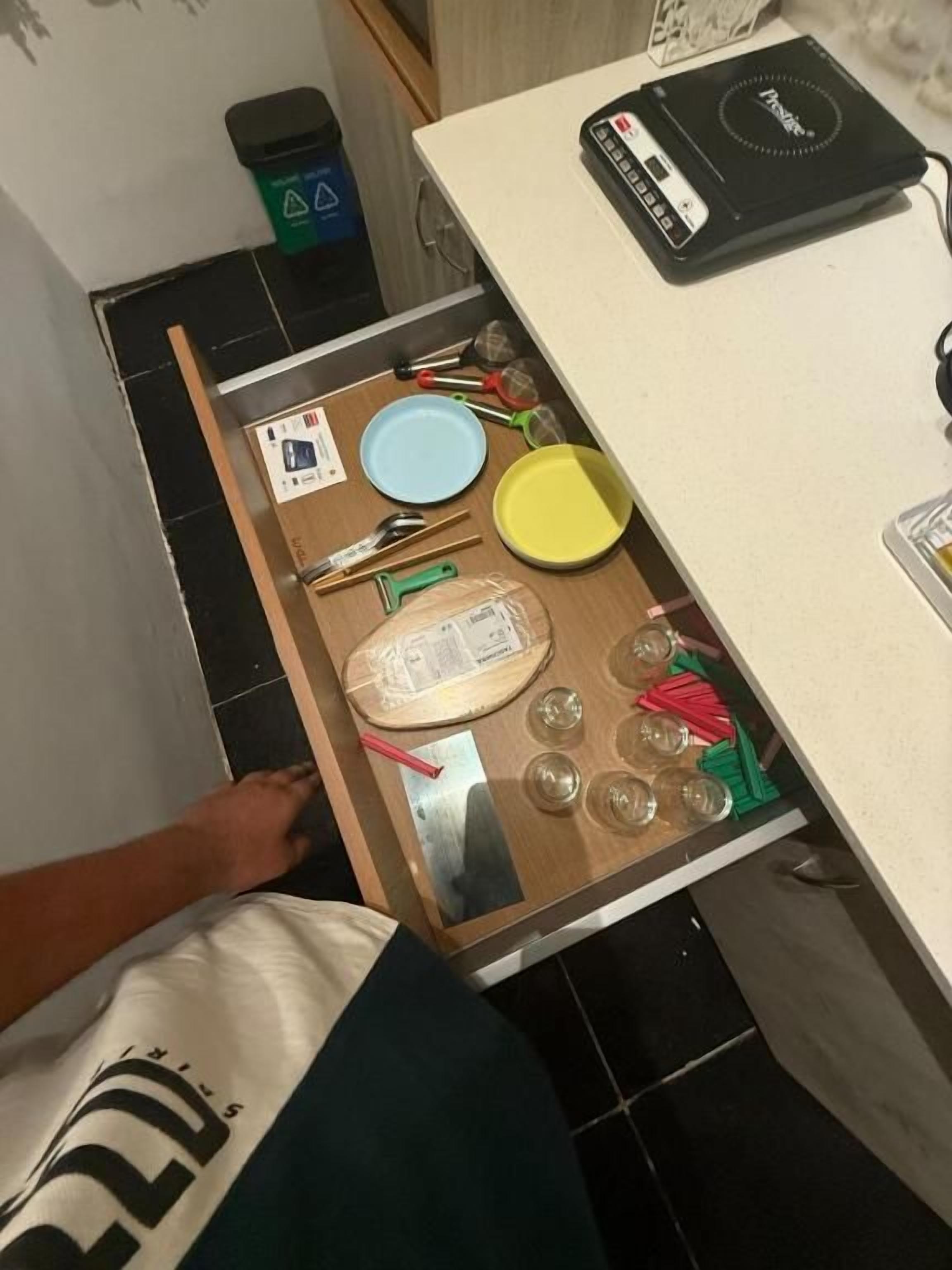 Un calaix amb diversos utensilis de cuina i un plat.