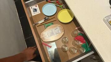 Un calaix amb diversos utensilis de cuina i un plat.