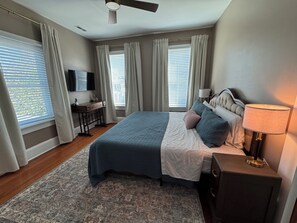 A bedroom with a bed, bedside table, lamp, and a desk with a chair. - DriftAway - Historic 3 Bedroom Wilmington Retreat (Wilmington)