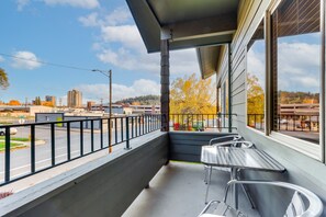 A balcony with a metal railing, a table, and two chairs. - Charming Condo in the Heart of CDA, Walking Distance to Lake (Coeur d'Alene)