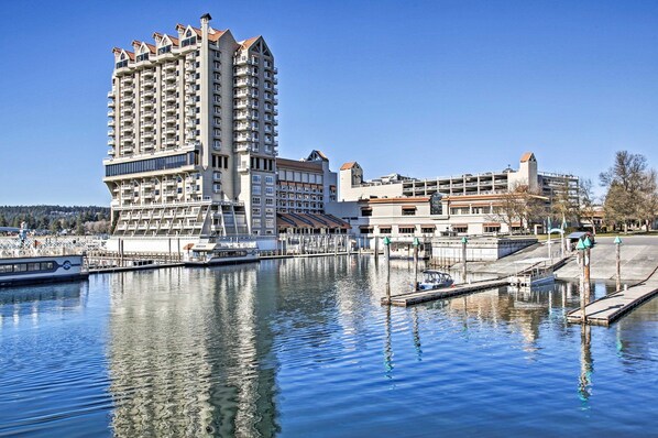A high-rise hotel with multiple balconies, a marina with boats, and a waterfront view.
