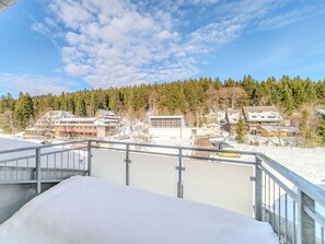 Eine verschneite Landschaft mit Gebäuden und einem Wald im Hintergrund.