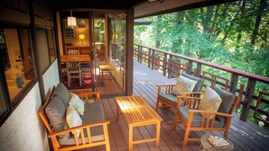 Une terrasse en bois aménagée avec du mobilier d’extérieur, notamment un canapé, des fauteuils et une petite table.