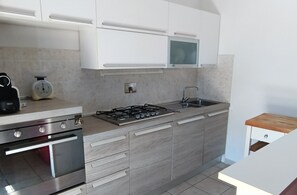 Eine moderne Küche mit Gasherd, Backofen und Mikrowelle.
