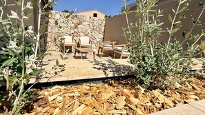 An outdoor seating area with stone walls and wooden furniture. - New villa for 6 people - Pool - Beach 800 m away (Fréjus)