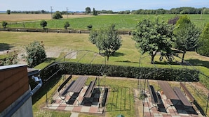 Blick auf einen Park mit Picknicktischen und einer Rasenfläche.