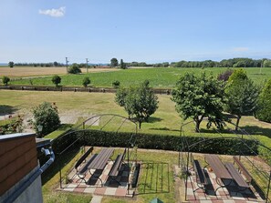 Une vue d’un parc avec des tables de pique-nique et un champ d’herbe.