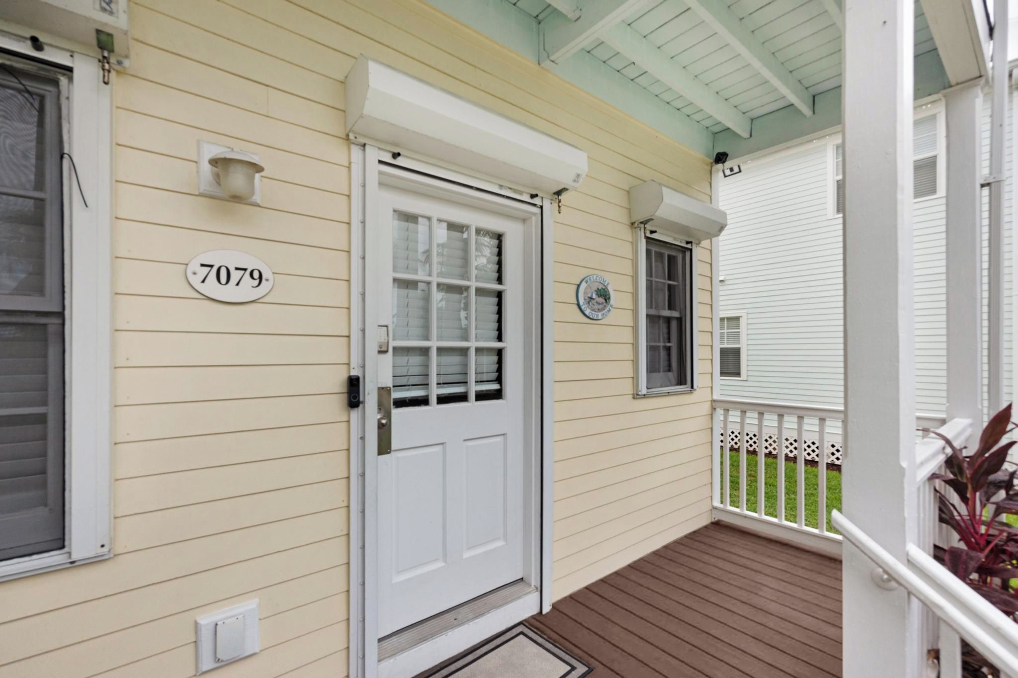 A house with a white door, a mailbox, and a number plate.