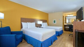 A hotel room with two beds, a desk, a chair, a television, and a refrigerator. - Days Inn Batesville! Your room for the Top 10 SEC Clash. 2 Double Beds. (Batesville)