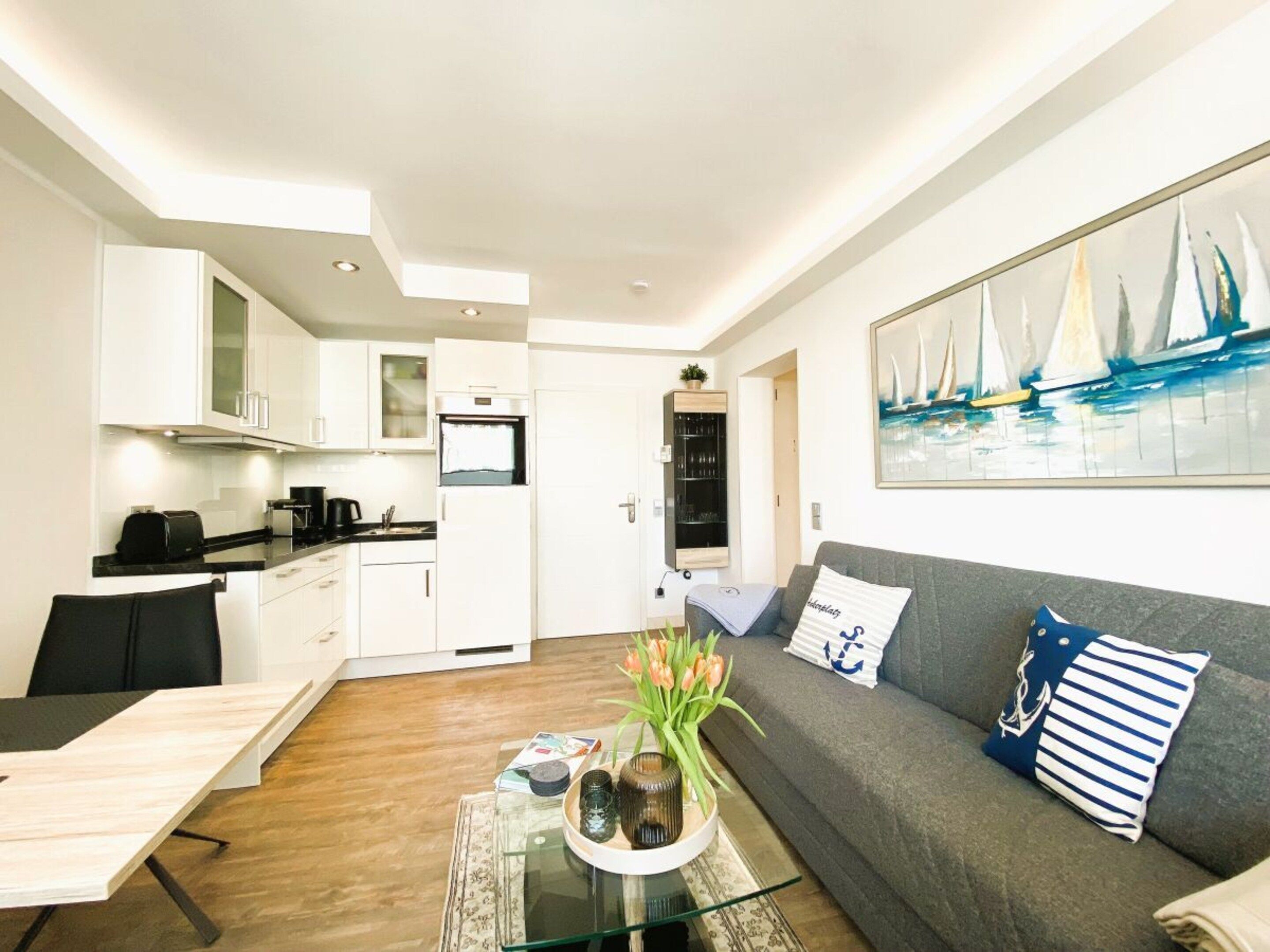 A modern apartment with a dining area, kitchen, and living room.