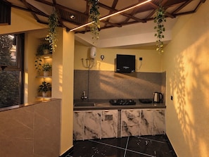 A modern kitchen with marble countertops, a built-in oven, and a coffee maker.