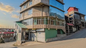 A multi-story building with a ground-level commercial space and upper residential units. - DORJE HILL STAY DARJEELING - KANCHENJUNGA VIEW COZY HOMESTAY (Darjeeling)