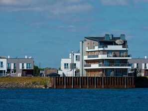 A multi-story residential building with balconies, located near a body of water. - Holiday Apartment With 4 Bedrooms (Kappeln)