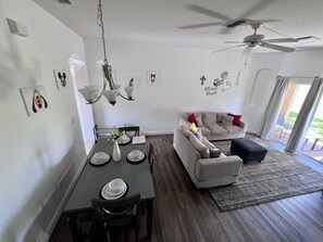 Una sala moderna con comedor, ventilador de techo y decoraciones de pared, incluyendo a Mickey Mouse.