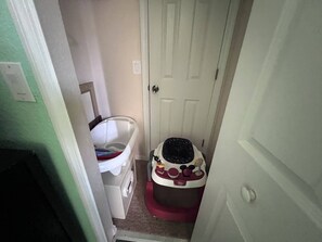 A narrow hallway with a white door, a white bathtub, and a small Disney-themed play area. - Regal Palms 3BR Gated TH sleeps 10 guests- Bergamo (Davenport)
