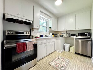 A kitchen with white cabinets, stainless steel appliances, and a patterned rug. - Newly Furnished Entire House (Toronto)