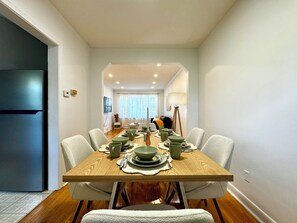 A dining area with a wooden table set for four, surrounded by chairs. - Newly Furnished Entire House (Toronto)