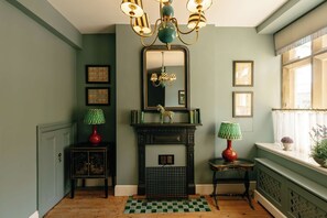 A room with a fireplace, a mirror, and a window with curtains. - Bank House - Luxury Stay in the Cotswolds (Gloucestershire)