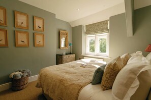 A bedroom with a large bed, a dresser, a mirror, and framed pictures on the wall. - Bank House - Luxury Stay in the Cotswolds (Gloucestershire)