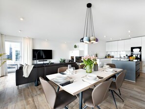 A modern kitchen with a dining area, a flat-screen TV, and a city view. - Holiday Apartment With 1 Bedroom (Kappeln)