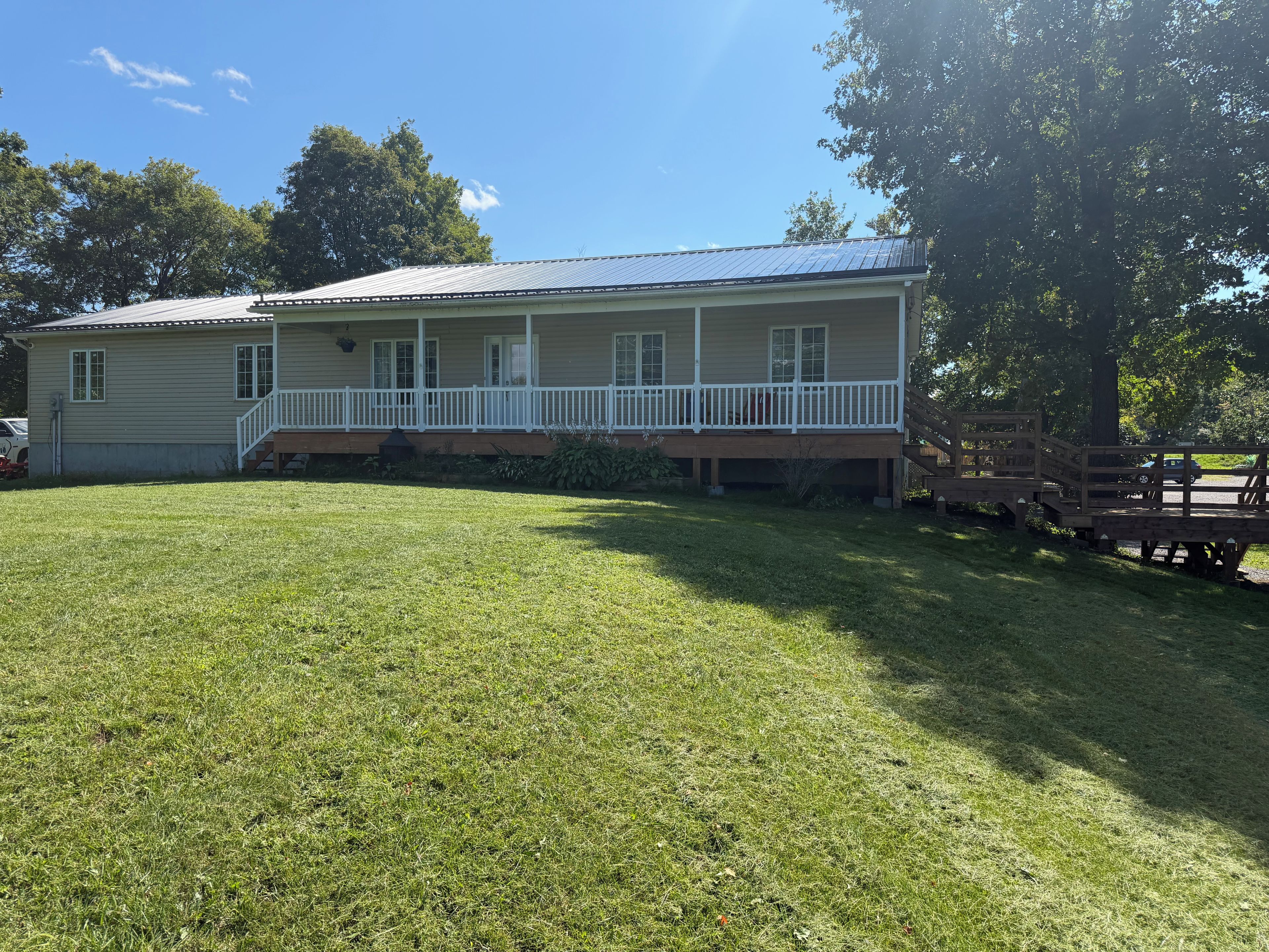 A two-story house with a front porch and a covered deck area.