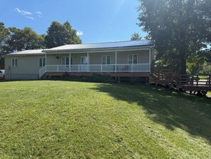 A two-story house with a front porch and a covered deck area.