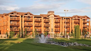 A multi-story hotel with balconies, a central fountain, and a well-maintained lawn. - WM BLOCK Lake House 1br dlx (Chelan)