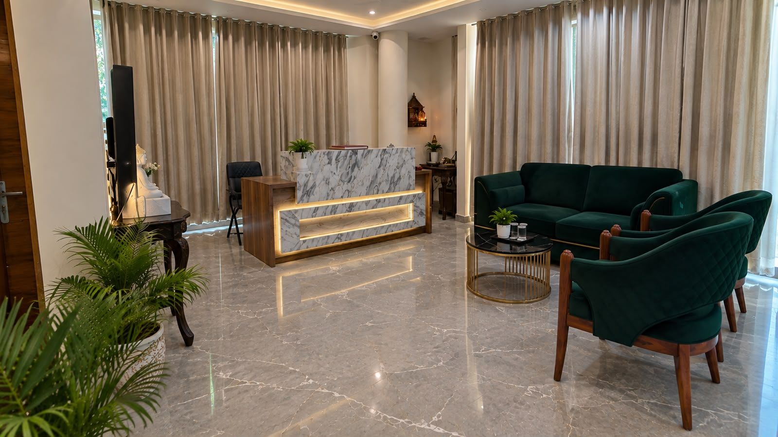A modern living room with a marble reception desk, green velvet sofas, and a round coffee table.