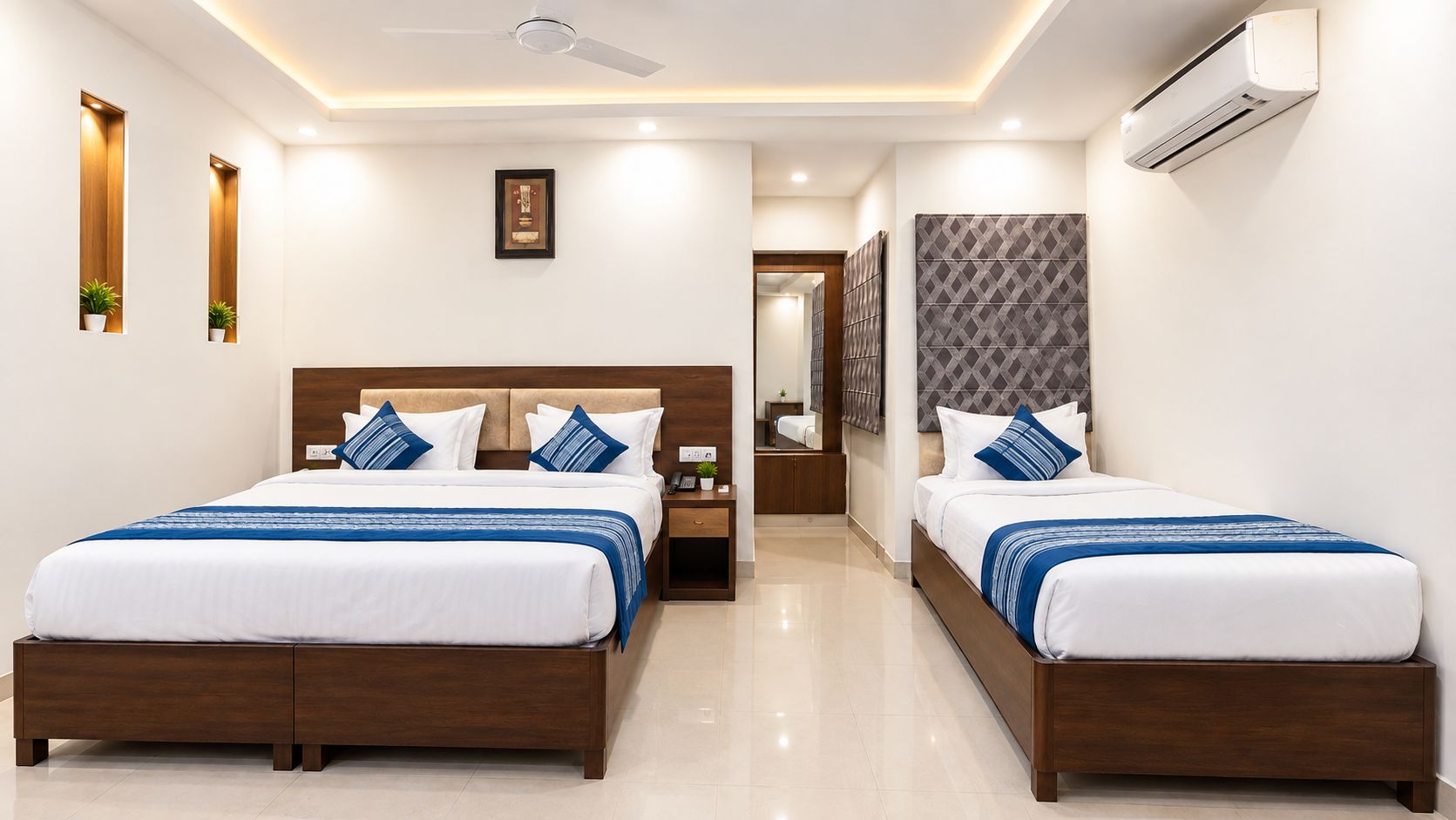 A hotel room with two beds, a ceiling fan, an air conditioning unit, and a framed picture on the wall.