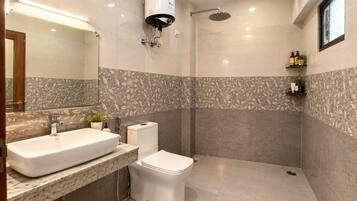 A modern bathroom with a large sink, toilet, and shower.