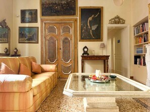 Ein Wohnzimmer mit einer Couch, einem Couchtisch und einem Bücherregal.