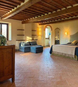 A bedroom with a bed, a sofa, and a large mirror. - Casale Tre Dame - Appartamento Il Convivio (Castiglion Fiorentino)