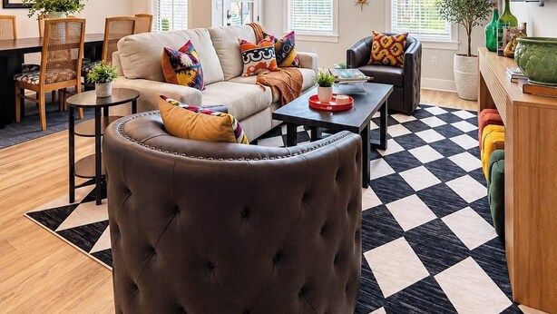 A living room with a sofa, ottoman, coffee table, and a ceiling fan. - The Archie, 2mi to Campus & Sq Velvet Ditch Villas (Oxford)