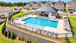 Zona residencial com piscina, varanda coberta e casas com arquitetura semelhante.