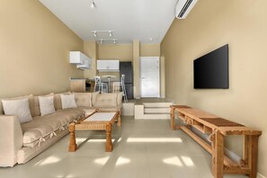 Ein modernes Wohnzimmer mit einer Couch, einem Couchtisch und einer Holzbank.