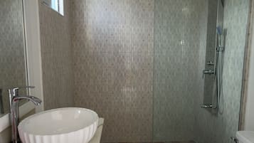 Un baño con lavabo, inodoro y zona de ducha.